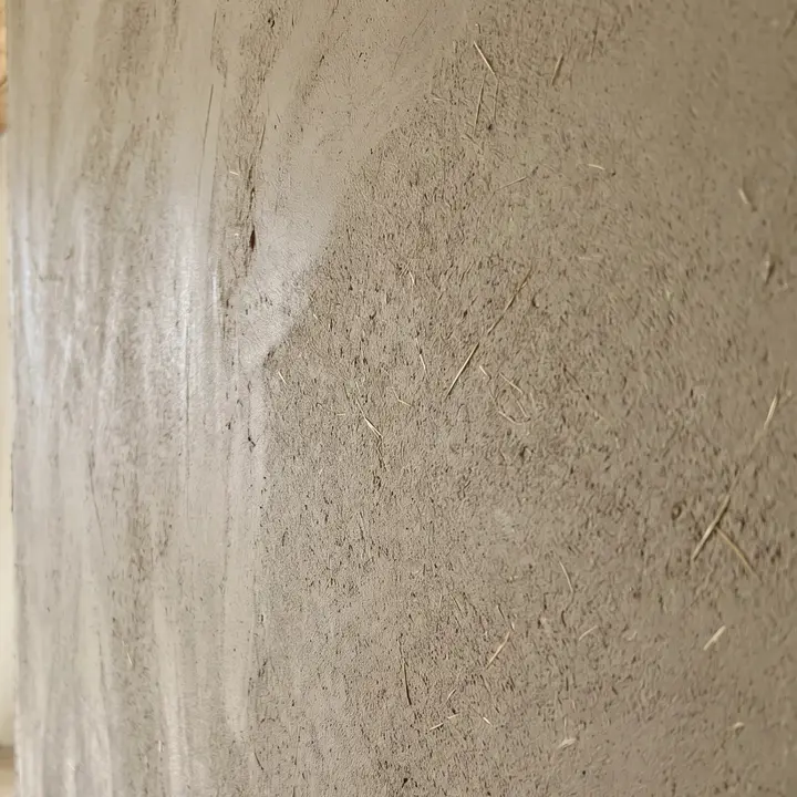 Wand in Lehmputz, sandiges Beige mit feinen Strohfasern
